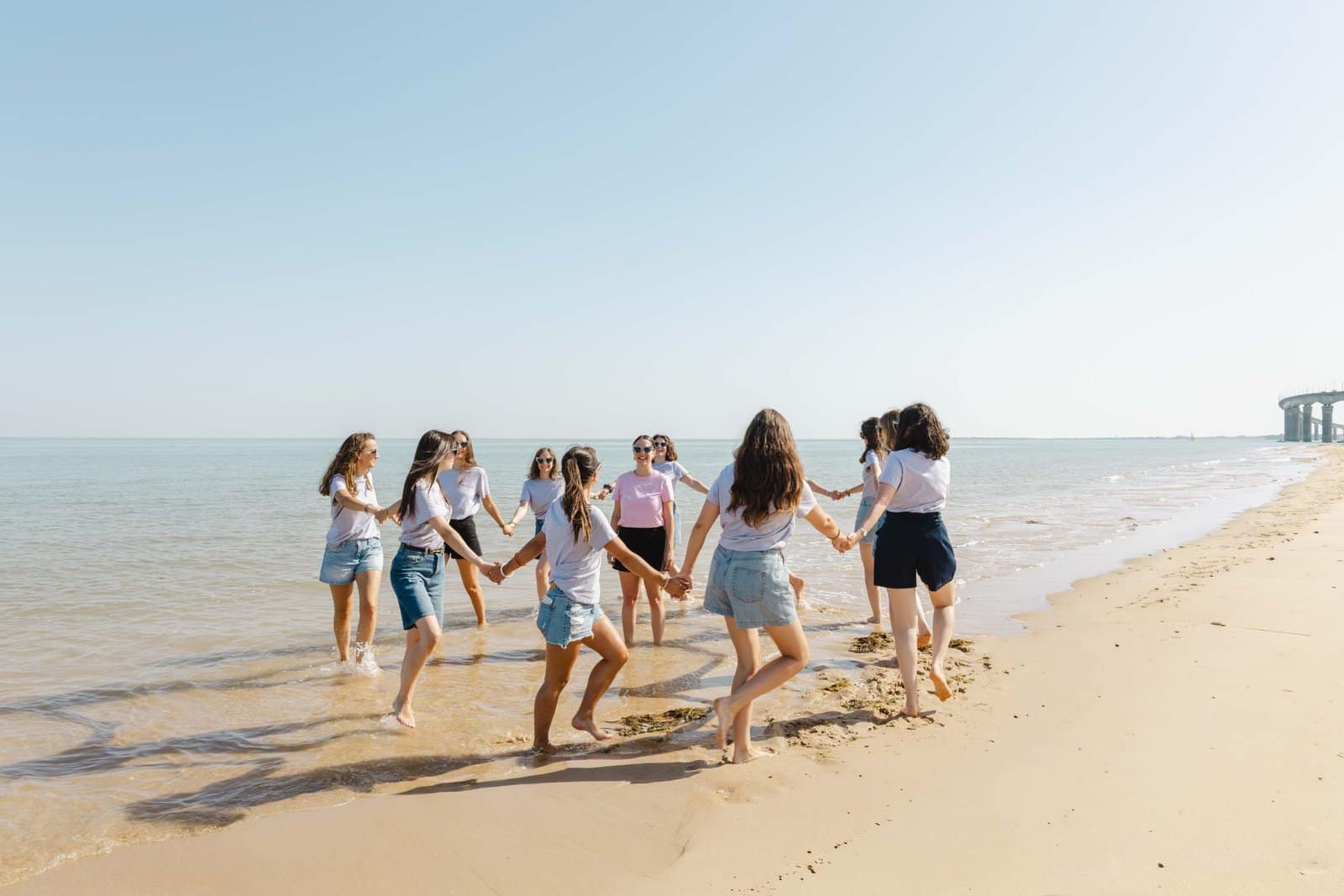 Groupe d'amies main dans la main sur la plage, séance EVJF
