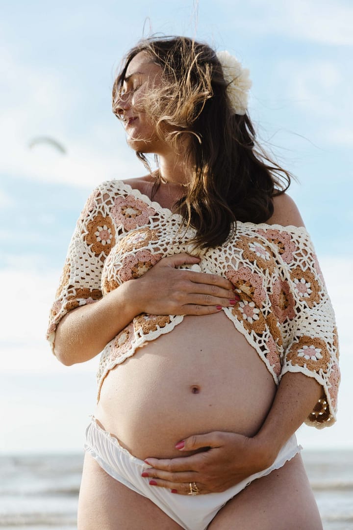 Future maman en robe fleurie, séance grossesse en extérieur