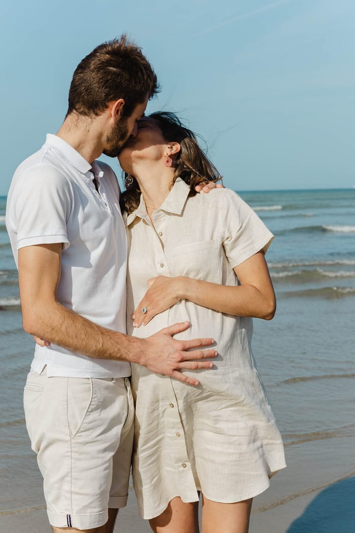 Parents enlacés lors d'une séance famille au bord de mer